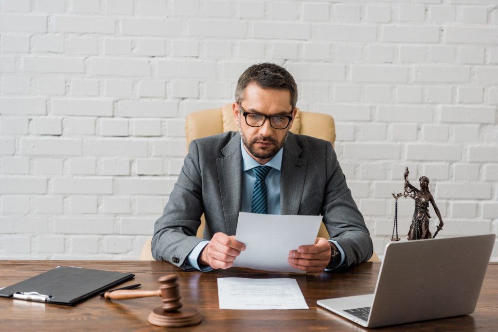 serious male judge working with papers in office